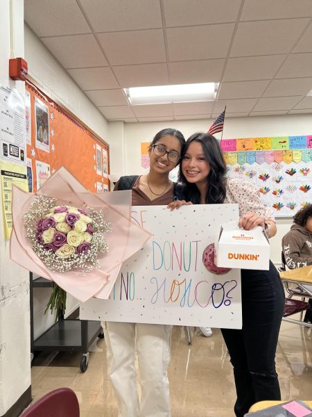 Evelyn Torres Salinas (right) asks Khushi Patel (left) with a Dunkin’ Donuts themed poster, Munchkins, and a flower bouquet. 
Photo courtesy of Harmonee Hallman.